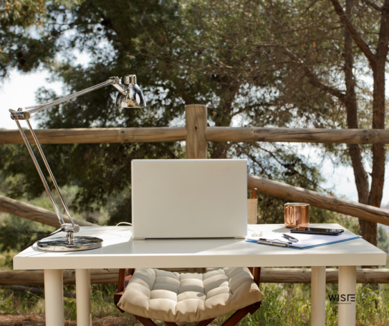 Πιθανός χώρος εργασίας ψηφιακού νομά, σε ένα γραφείο με laptop σε εξωτερικό χώρο με δέντρα στο φόντο.